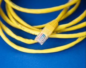 Yellow Ethernet cable on blue background - Inderly IT - Toronto IT support services